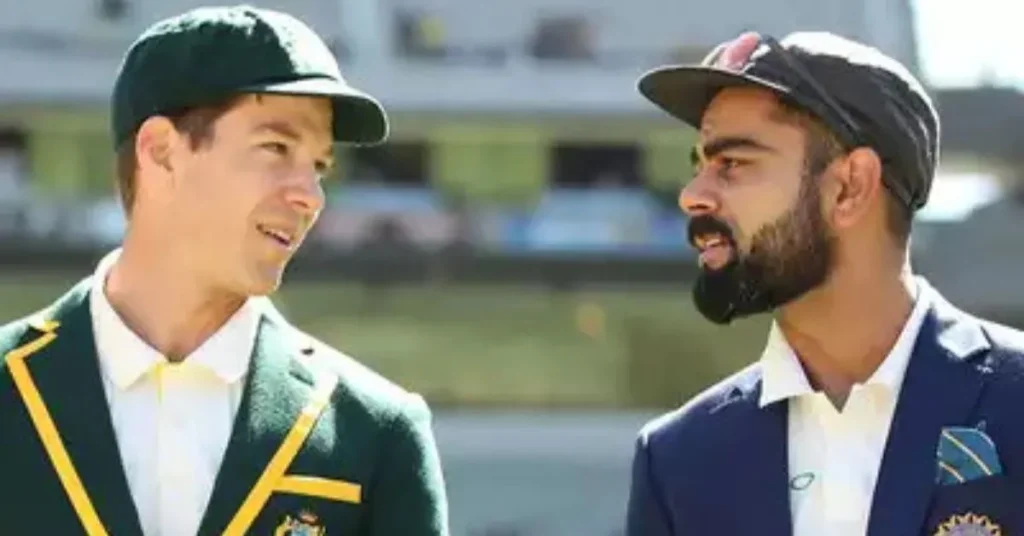 The image shows two cricketers in conversation on a cricket field. One is wearing a green blazer with yellow trim and a matching cap, representing Australia, while the other is dressed in a navy blazer and a black cap, representing India. Both appear to be team captains or prominent players, engaging in a discussion before or during a match.