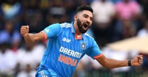 Indian cricketer in action wearing the blue 'Dream11 India' jersey, celebrating passionately with a clenched fist and an intense expression during a match.